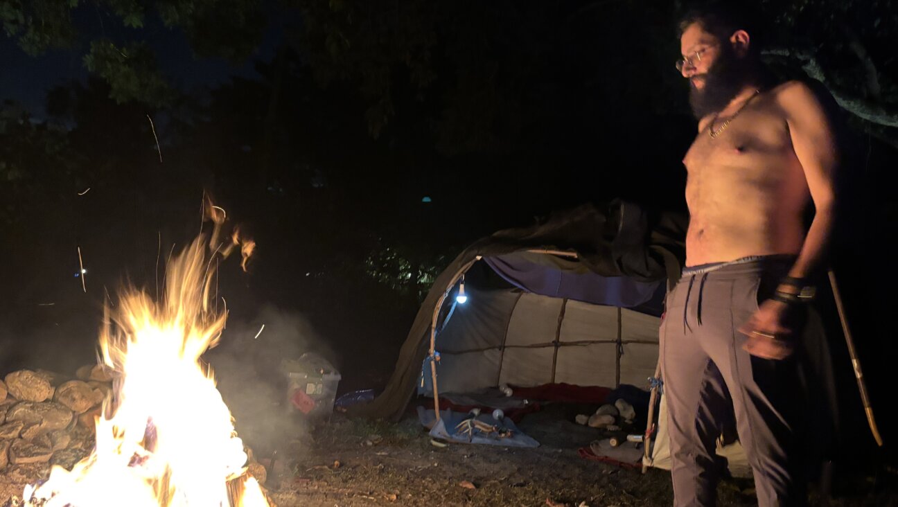 Daniel Herman, who leads a sweat lodge in Florida, stands before the fire.