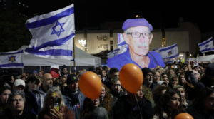 Attendees at a vigil for the four deceased hostages returned on Thursday, Feb. 20, 2025, held up a large cutout of one of the captives, Oded Lifshitz. (Alon Gilboa)