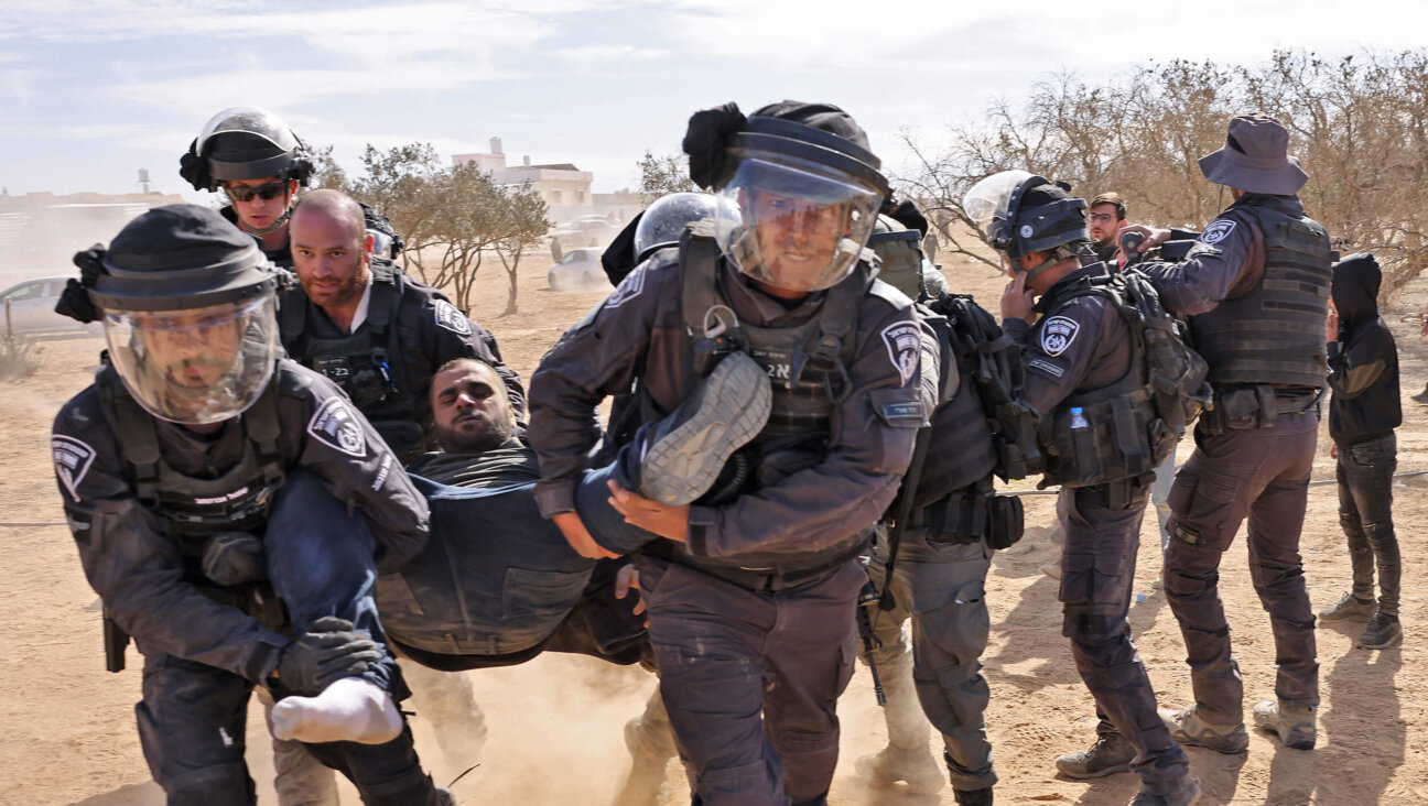 Israeli police detain a man as Bedouins protest against a forestation project by the Jewish National Fund in the southern Israeli village of Sa’we al-Atrash in the Neguev Desert on Jan. 12, 2022. 