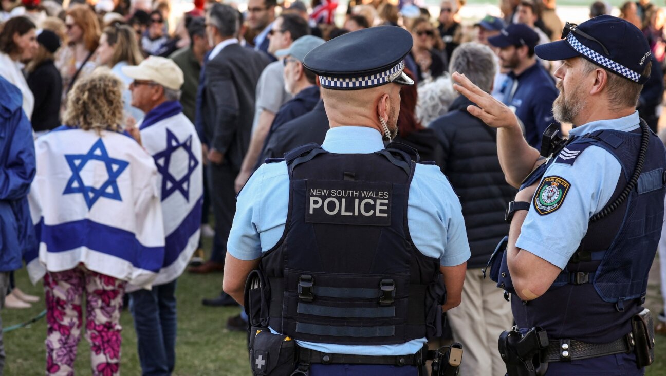 New South Wales police officers stand near members of the Australian Jewish community holding a memorial service for six Israeli hostages whose bodies were recovered from the Gaza Strip, at Sydney’s Bondi Beach on Sept. 2, 2024. (David Gray / AFP via Getty Images)