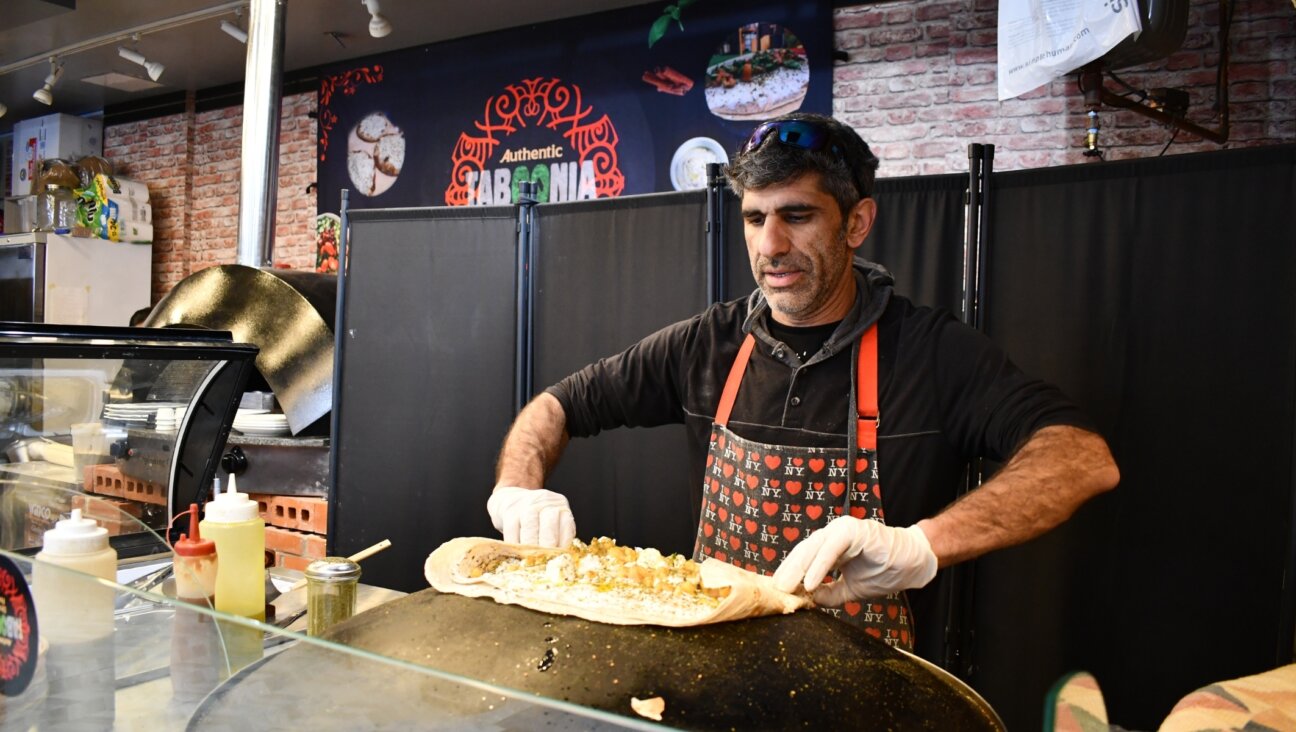 Raif Rashed, an Israeli Druze and the owner of Taboonia, wraps up a pita with labneh. (Jackie Hajdenberg)