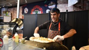 Raif Rashed, an Israeli Druze and the owner of Taboonia, wraps up a pita with labneh. (Jackie Hajdenberg)