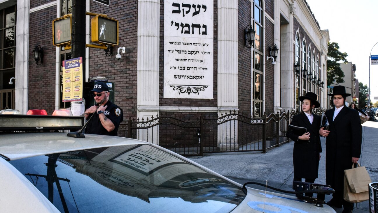 A member of the New York Police Department patrols in front of the synagogue Congregation Bais Yaakov Nechamia Dsatmar on October 13, 2023. (Photo by Stephanie Keith/Getty Images)