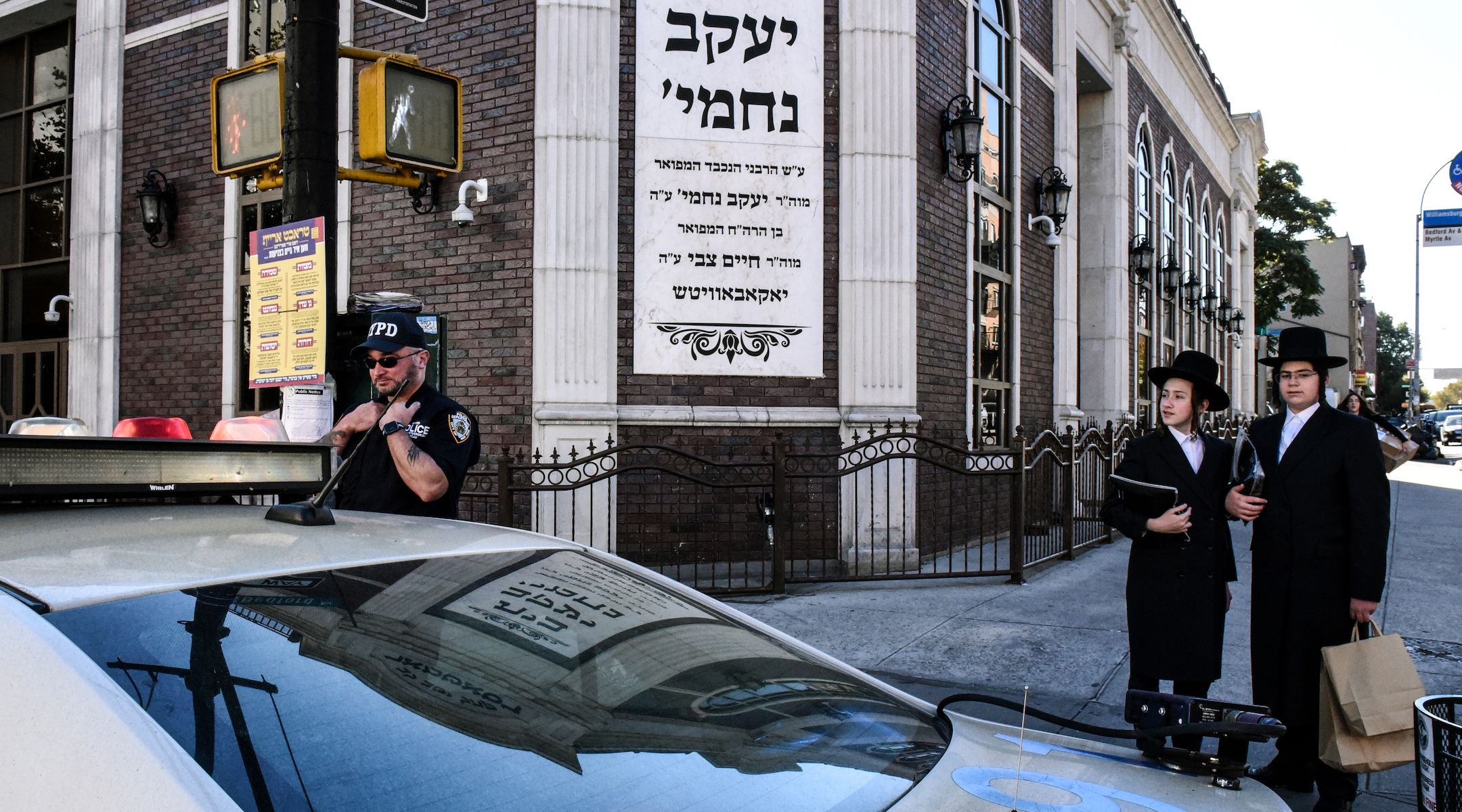 A member of the New York Police Department patrols in front of the synagogue Congregation Bais Yaakov Nechamia Dsatmar on October 13, 2023. (Photo by Stephanie Keith/Getty Images)