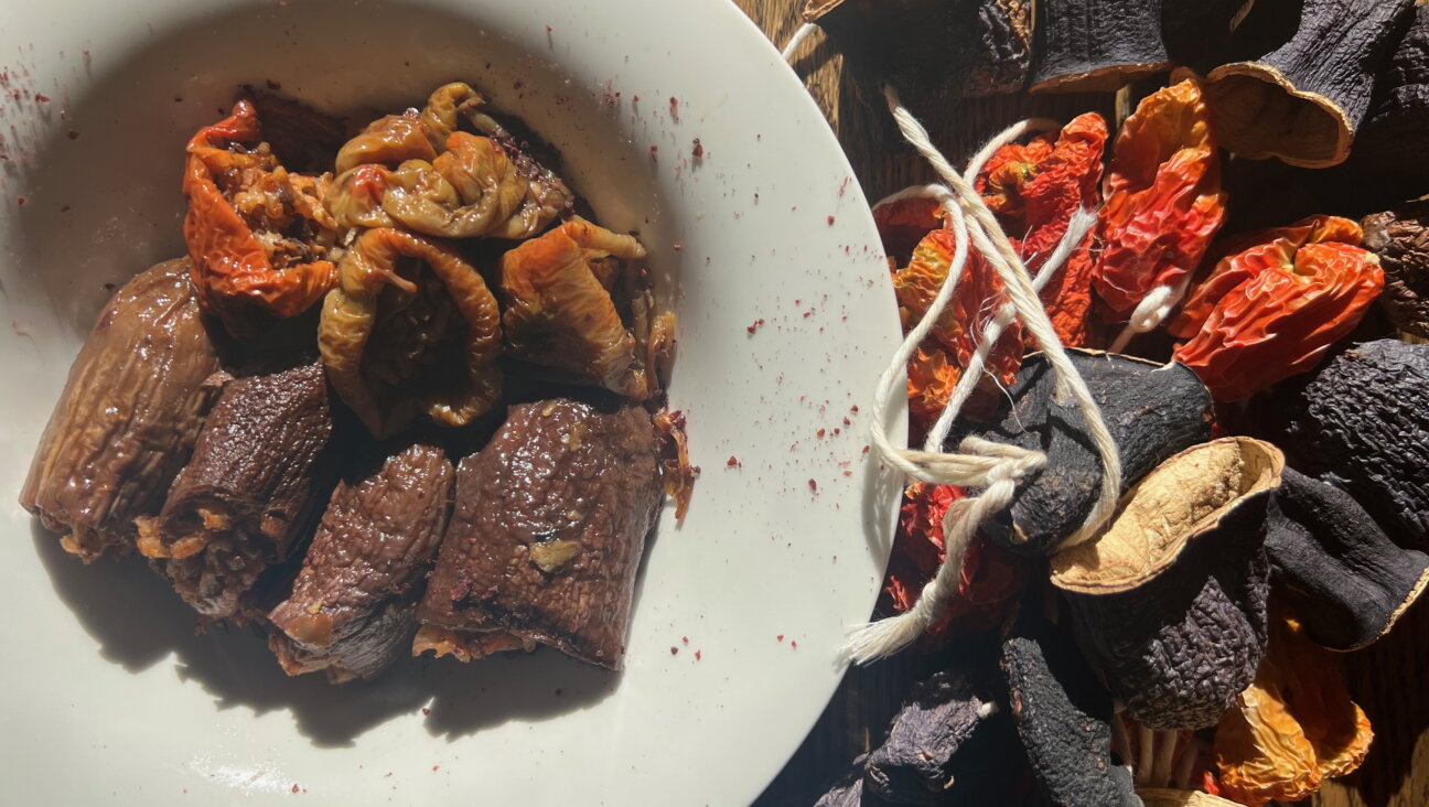 A platter of stuffed, dried eggplants and peppers beside the raw ingredients.