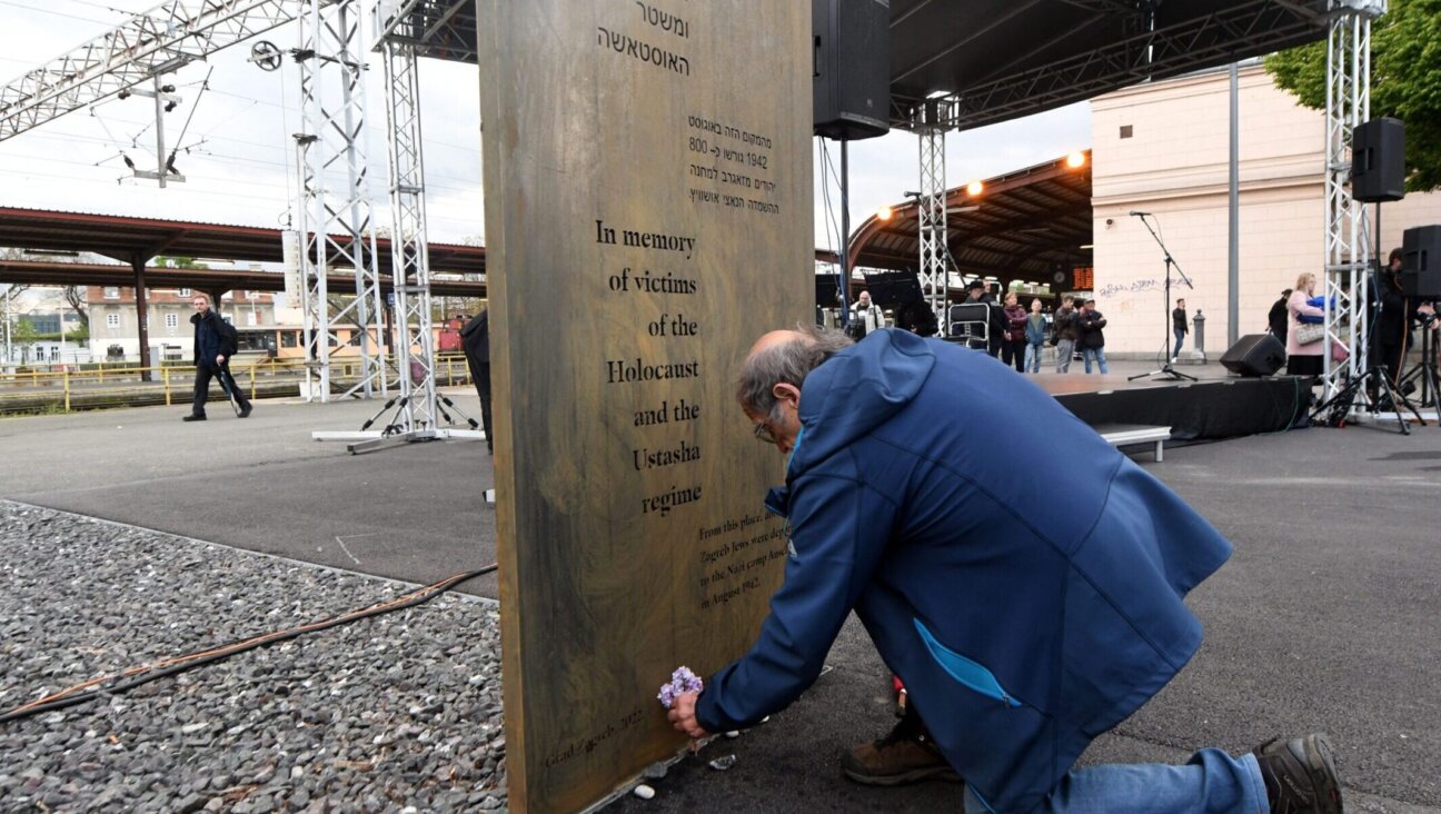 A man placed a bouquet of flowers in front of a memorial plaque near the 12-meter (39-foot) high memorial for the victims of Holocaust and Croatia’s pro-Nazi World War II regime unveiled on April 27, 2022, erected just next to Zagreb’s main railway station. (Denis Lovrovic/AFP via Getty Images)