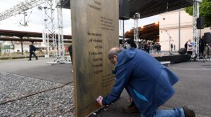 A man placed a bouquet of flowers in front of a memorial plaque near the 12-meter (39-foot) high memorial for the victims of Holocaust and Croatia’s pro-Nazi World War II regime unveiled on April 27, 2022, erected just next to Zagreb’s main railway station. (Denis Lovrovic/AFP via Getty Images)