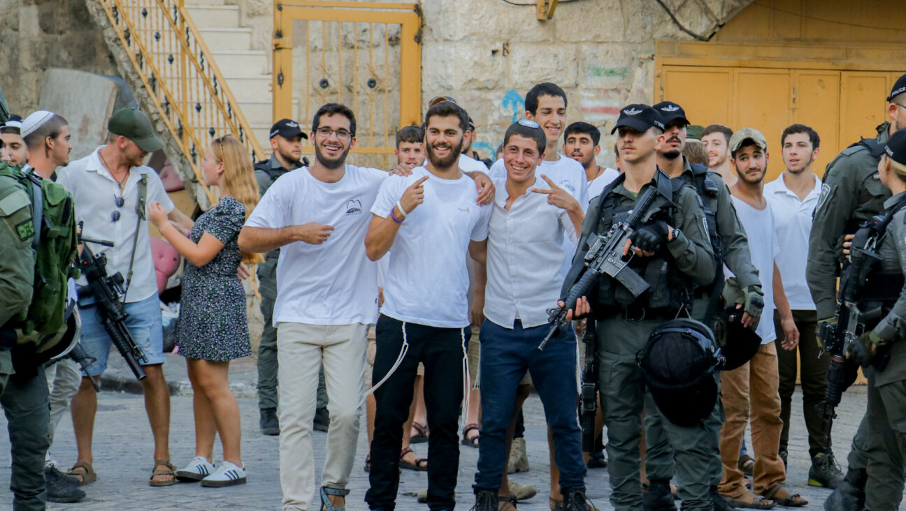 Settlers in the West Bank pose for a photo as Israeli soldiers stand nearby during a march. in Hebron, on Sept. 28, 2024. 