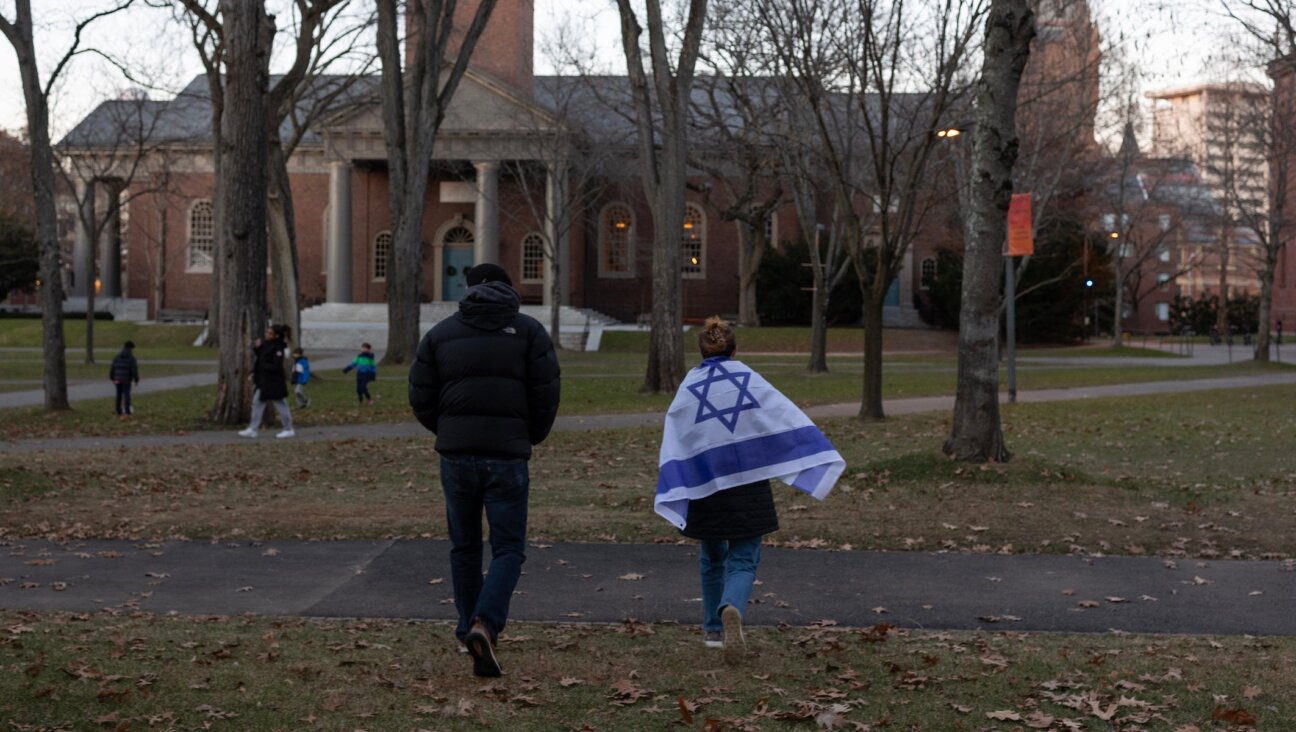 A person draped in an Israeli flag attends a menorah lighting ceremony at Harvard University on Dec. 13, 2023, Cambridge, Massachusetts. (Andrew Lichtenstein/Corbis via Getty Images)