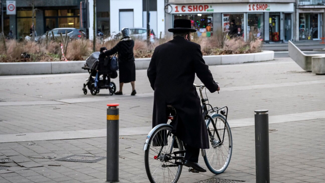An Orthodox Jewish man bicycles in a neighborhood of Antwerp, Belgium, January 21, 2021. (Dirk Waem/Belga Mag/AFP via Getty Images)