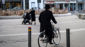 An Orthodox Jewish man bicycles in a neighborhood of Antwerp, Belgium, January 21, 2021. (Dirk Waem/Belga Mag/AFP via Getty Images)