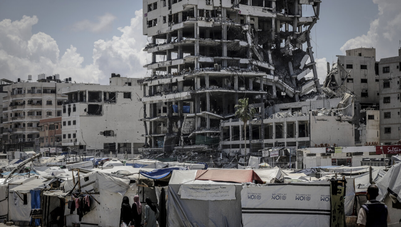 Tents stand beneath a destroyed building in the Al-Rimal neighborhood of Gaza City.