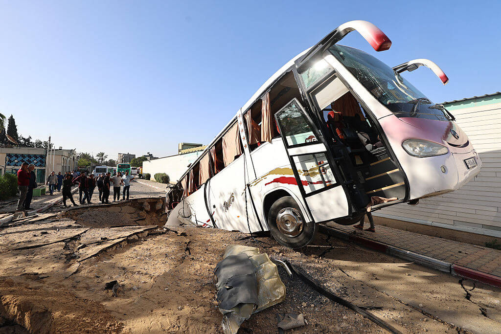 People check a bus inside a crater on May 14, 2025, in the aftermath of an Israeli strike in Khan Yunis in the southern Gaza Strip. (Getty)