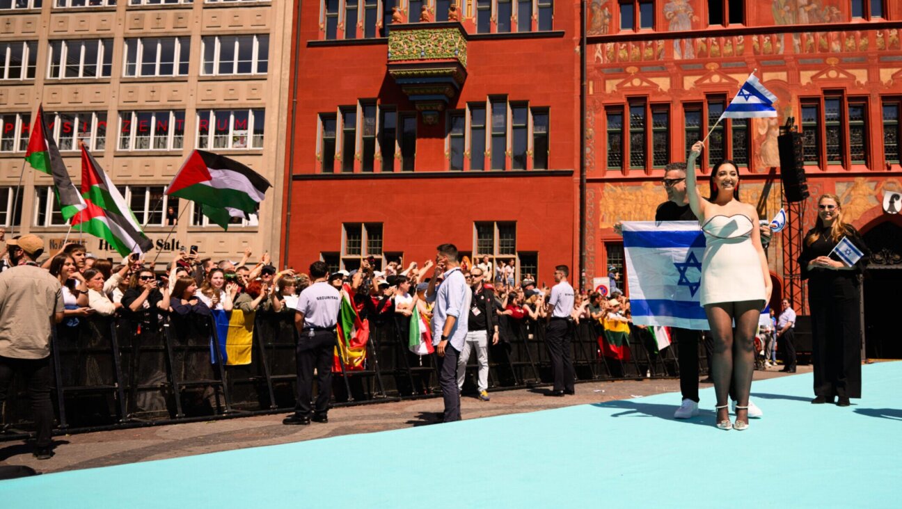 Protesters wave Palestinian flags as Yuval Raphael, representing Israel, walks the Turquoise Carpet at the opening of the 69th Eurovision Song Contest in Basel, Switzerland, May 11, 2025. (Harold Cunningham/Getty Images)