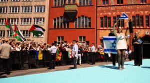 Protesters wave Palestinian flags as Yuval Raphael, representing Israel, walks the Turquoise Carpet at the opening of the 69th Eurovision Song Contest in Basel, Switzerland, May 11, 2025. (Harold Cunningham/Getty Images)
