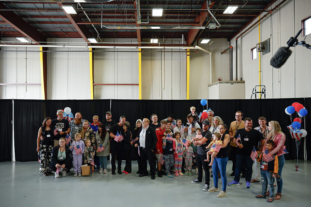 Newly arrived South Africans wait to hear welcome statements from U.S. government officials in a hangar near Washington Dulles International Airport on May 12.