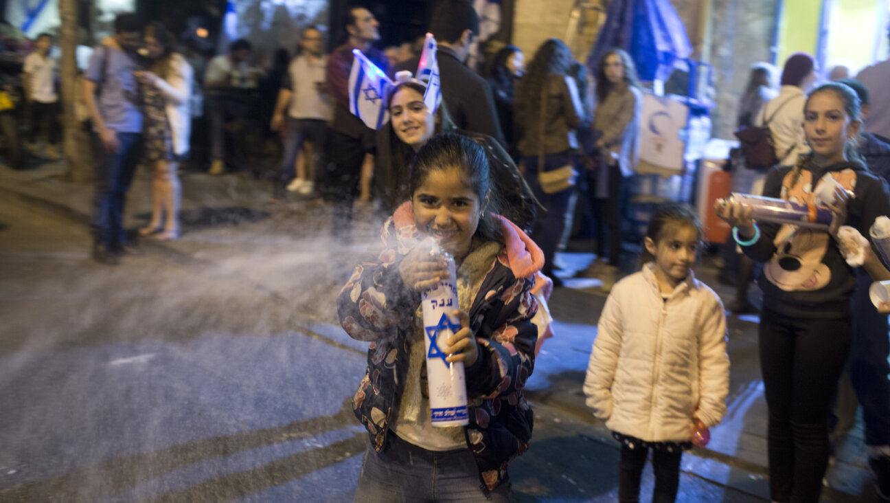 An Israeli girl sprays foam during Yom Ha'atzmaut celebrations in Jerusalem. Eighth graders from the Milken school were attacked by local Israeli teens after foam-spraying got out of hand.