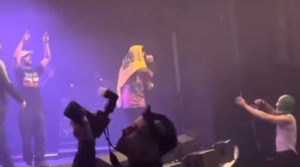 Kneecap band member Liam O’Hanna displaying the Hezbollah flag at a November 2024 concert. (Screenshot)