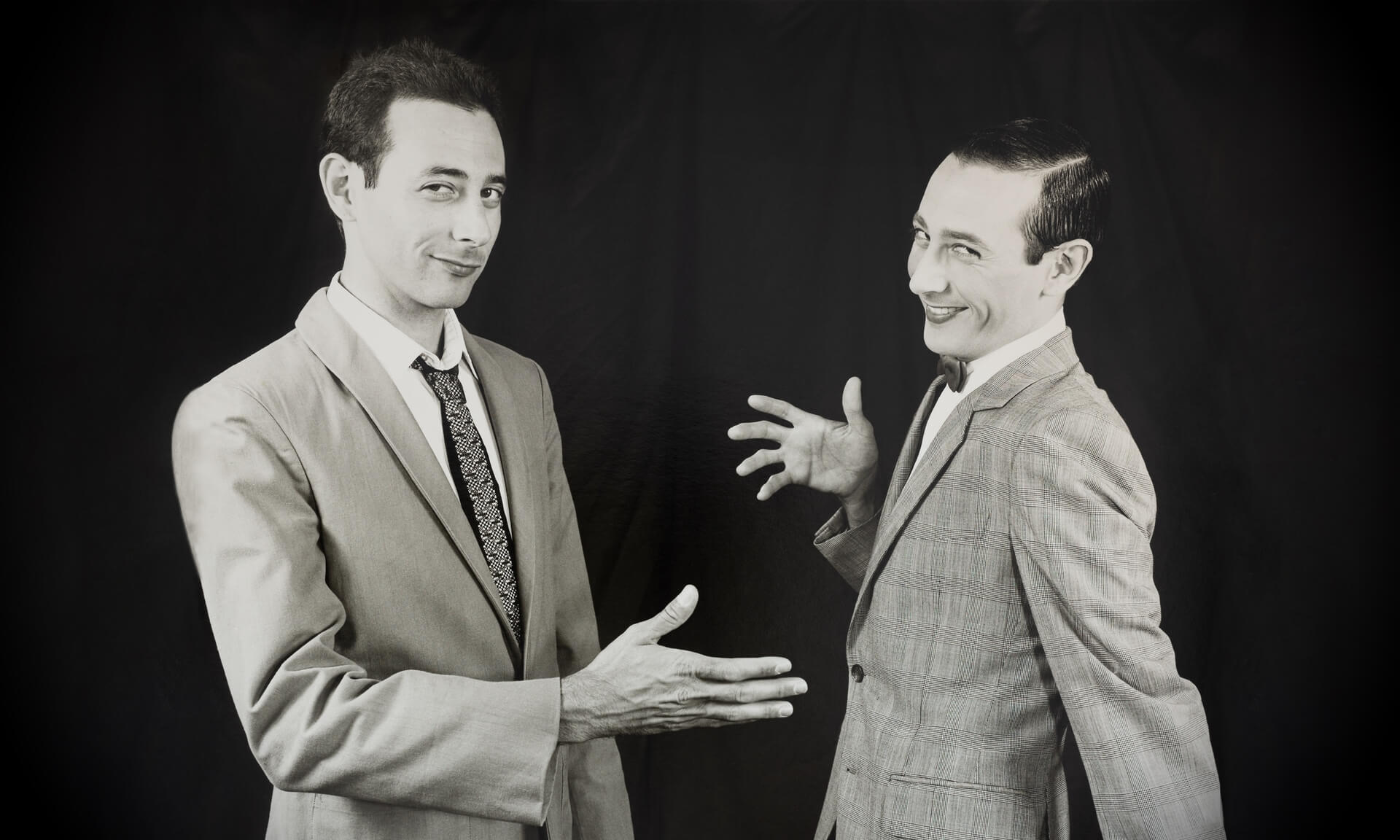 Paul Reubens (L) reaches out to shake the hand of his alter ego, Pee-wee Herman.