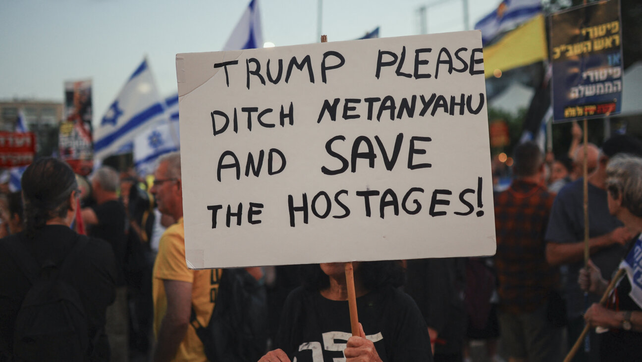 Demonstrators wave Israeli flags and hold signs at a protest in Tel Aviv on May 22.