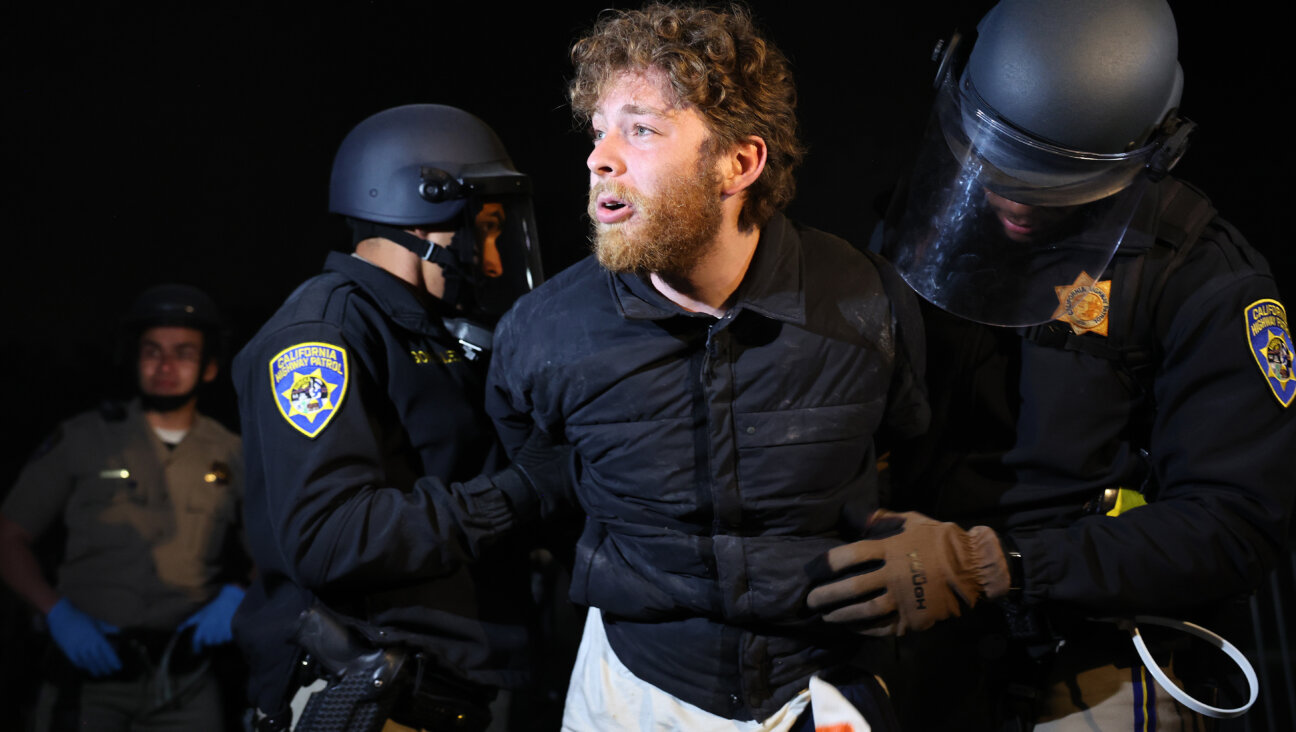 California police officers detain a protestor, who said they are a Jewish USC student, while clearing a pro-Palestinian encampment at USC, May 2, 2024. 