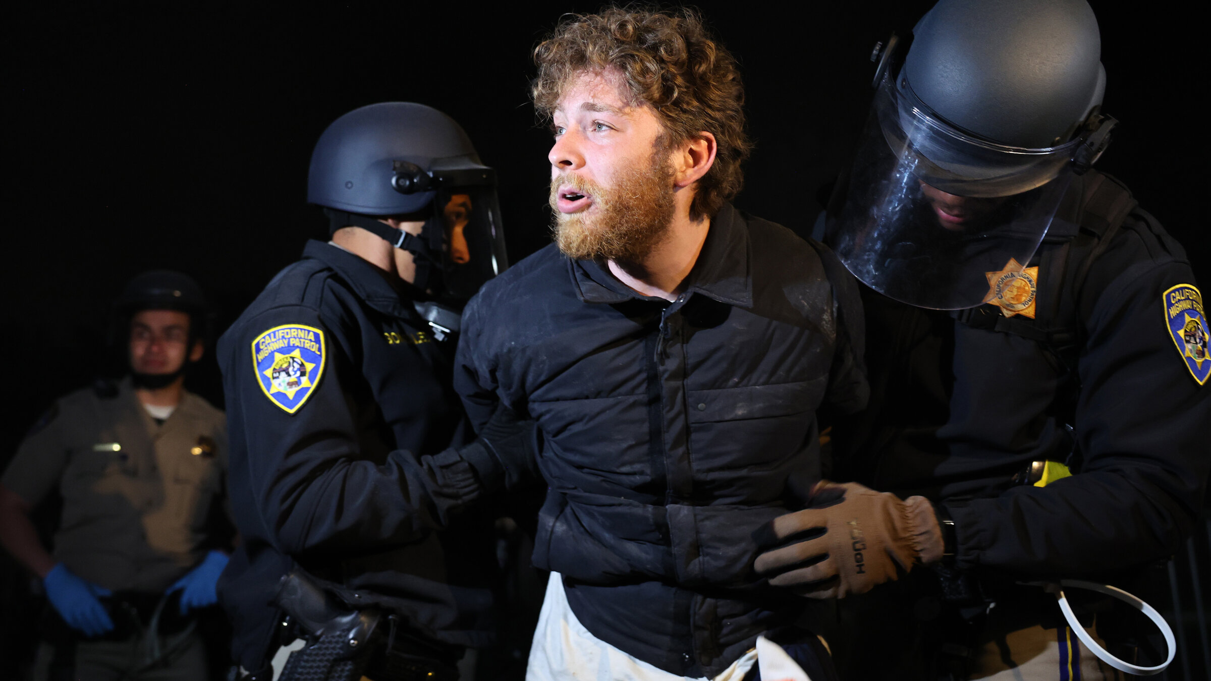 California police officers detain a protestor, who said they are a Jewish USC student, while clearing a pro-Palestinian encampment at USC, May 2, 2024.