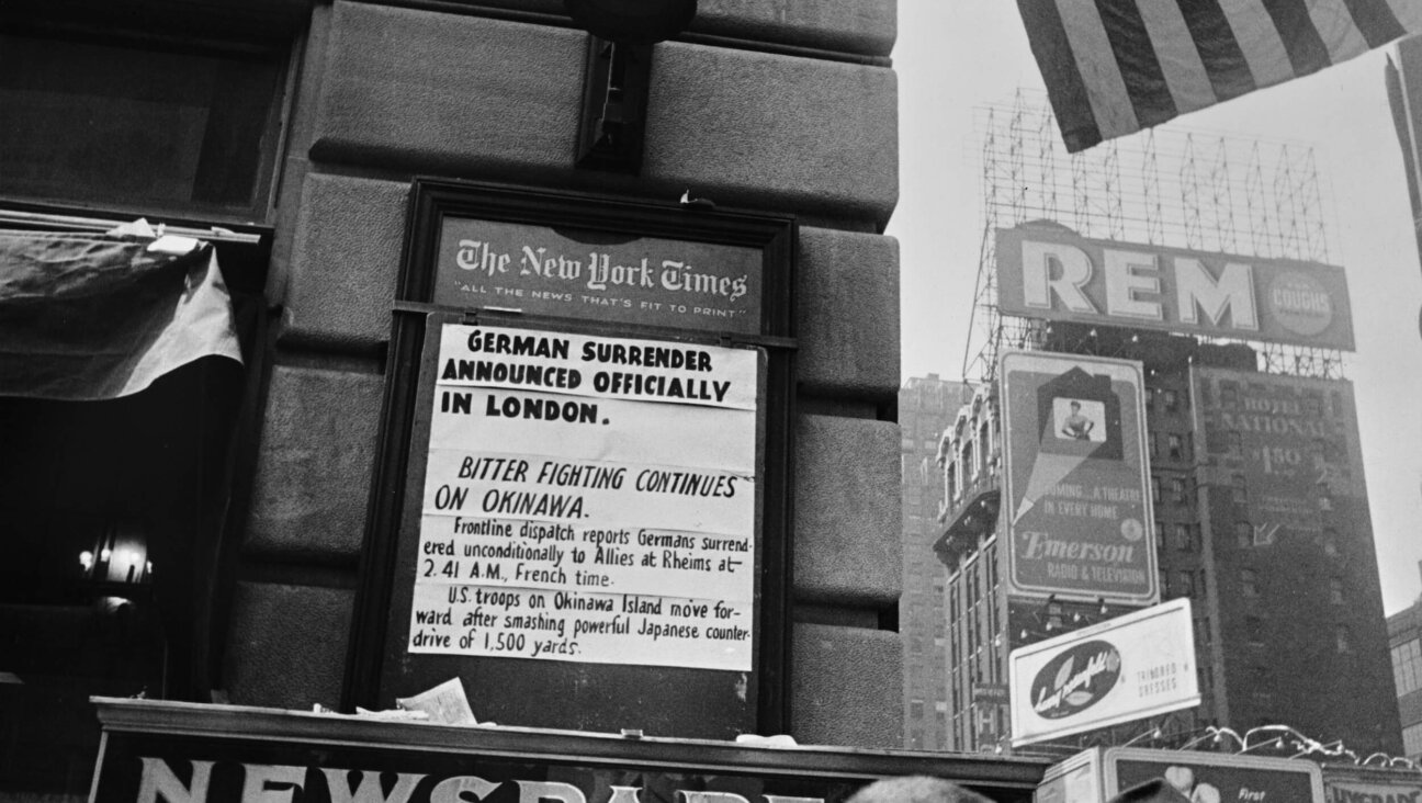 A New York Times newsboard announces Germany's surrender, marking the end of WWII in Europe, on May 8, 1945. 