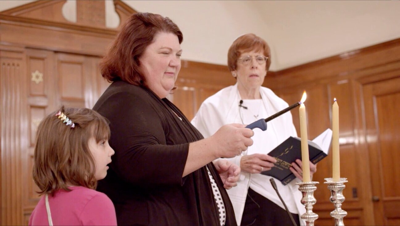 Karen Arenson and her daughter Emily light the Shabbat candles at Temple Emanu-El in Dothan, Alabama, as Rabbi Lynne Goldsmith looks on, in a scene from the 2016 documentary "There Are Jews Here."