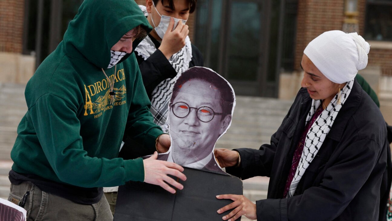 Pro-Palestinian demonstrators adjust a photo of the University of Michigan President Santa Ono as people gather for a mock trial against the University of Michigan’s Board of Regents on the university’s campus in Ann Arbor, Michigan, on April 21, 2025. (Jeff Kowalsky/AFP via Getty Images)