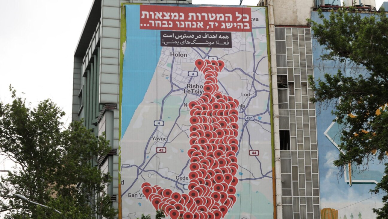 People drive past an anti-Israel billboard featuring the shape of a traditional Yemeni dagger made of map pins and sentences reading “All targets are within reach, we choose’ in Hebrew and ‘All targets are available, now Yemeni missiles’ in Persian, in Tehran’s Palestine square on May 5, 2025. (Atta Kenare/AFP via Getty Images)