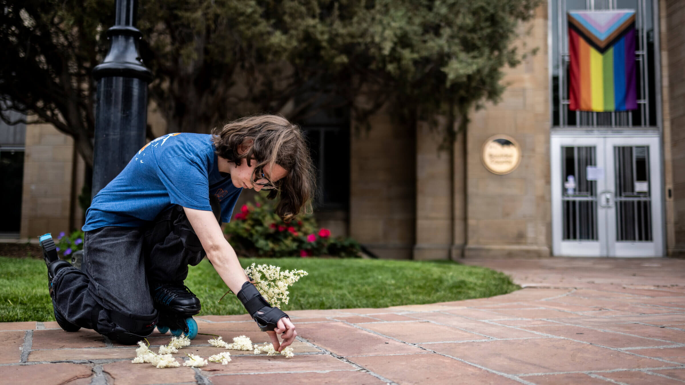 Wilbur Thayer, 17, of Boulder, lays flowers at the site of the attack outside the Boulder County Courthouse on June 2, 2025 in Boulder, Colorado.