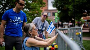 Lisa Turnquist of Louisville, Colorado, lays flowers and a flag at the site of the attack outside the Boulder County Courthouse on June 2, 2025 in Boulder.