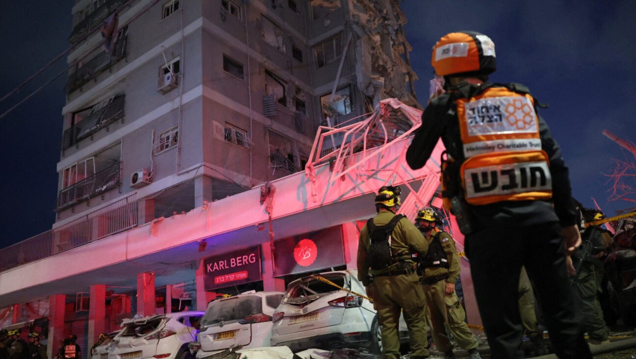 Responders work beside a damaged building following a strike by an Iranian missile in the Israeli city of Bat Yam, south of Tel Aviv, early on June 15, 2025. (Jack Guez/AFP via Getty Images)