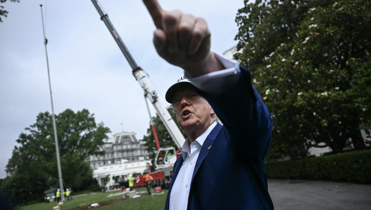 Donald Trump observes the installation of a flag pole.