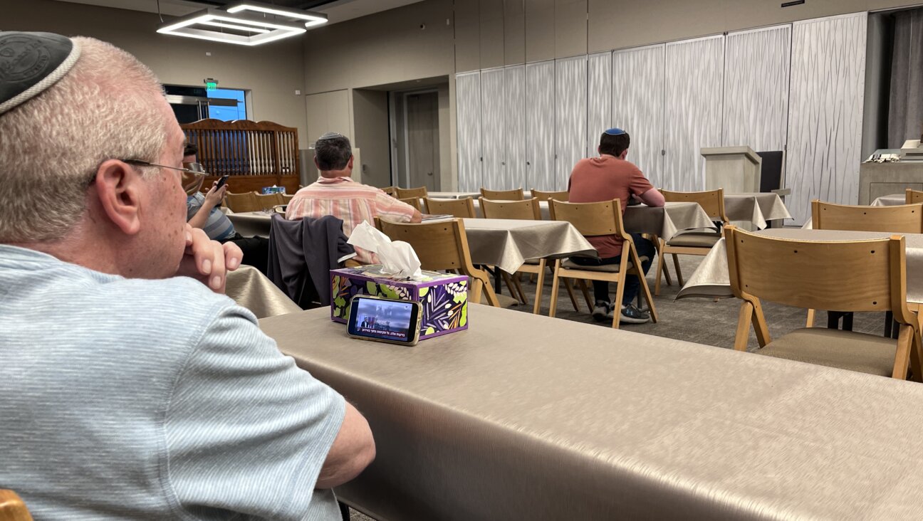 Benny Factor watches Israeli TV on his phone before evening prayers June 12 at Young Israel of Century City, an Orthodox synagogue in Los Angeles.