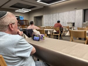 Benny Factor watches Israeli TV on his phone before evening prayers June 12 at Young Israel of Century City, an Orthodox synagogue in Los Angeles.