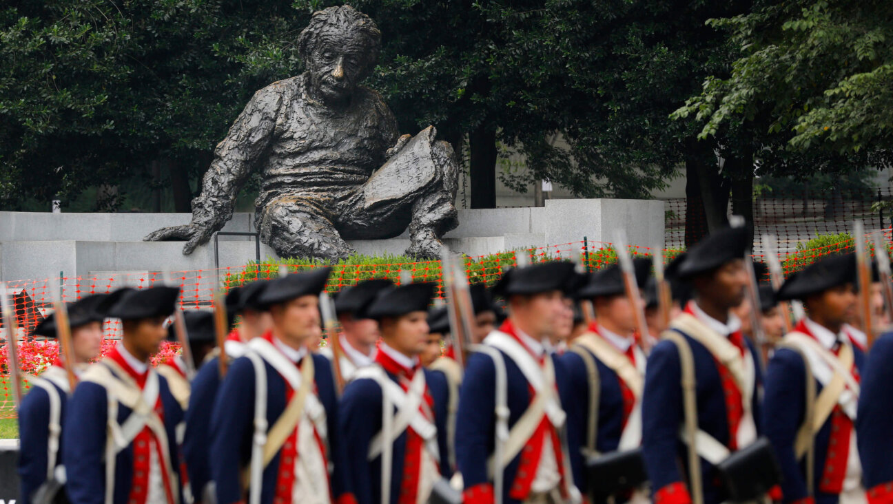 With the Albert Einstein Memorial statue in the background, members of the U.S. Army dressed in Revolutionary War uniforms march along Constitution Avenue during a military parade on June 14 in Washington, D.C.