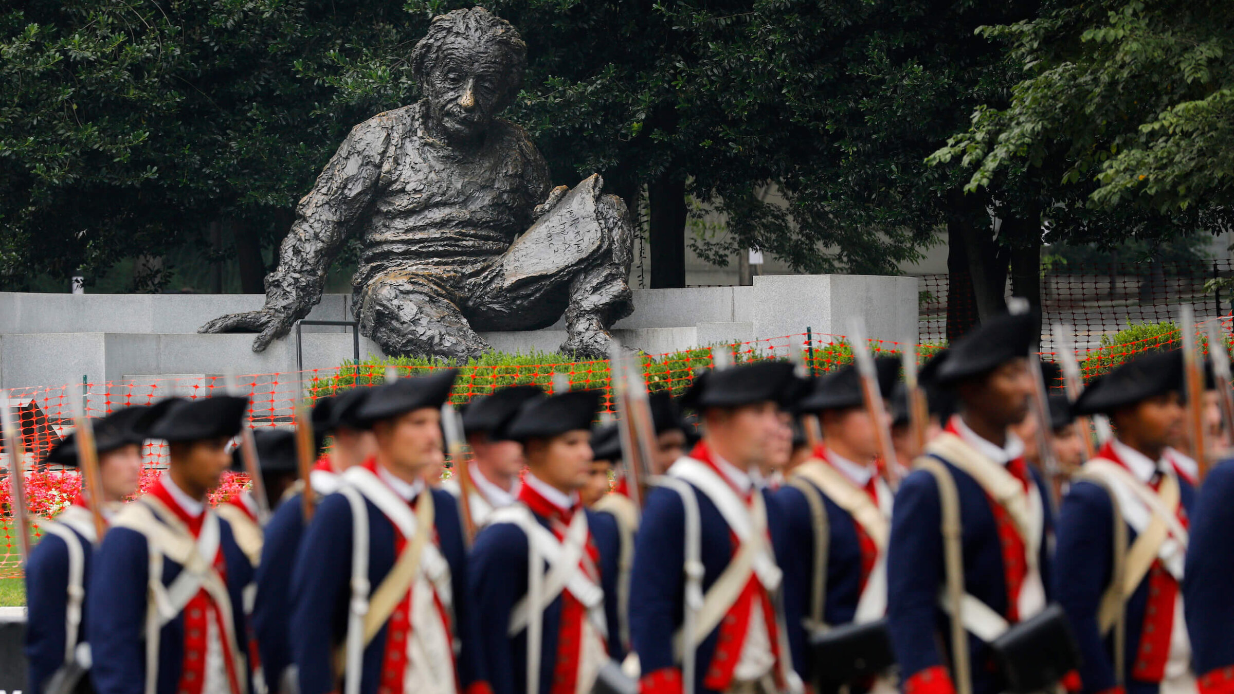 With the Albert Einstein Memorial statue in the background, members of the U.S. Army dressed in Revolutionary War uniforms march along Constitution Avenue during a military parade on June 14 in Washington, D.C.