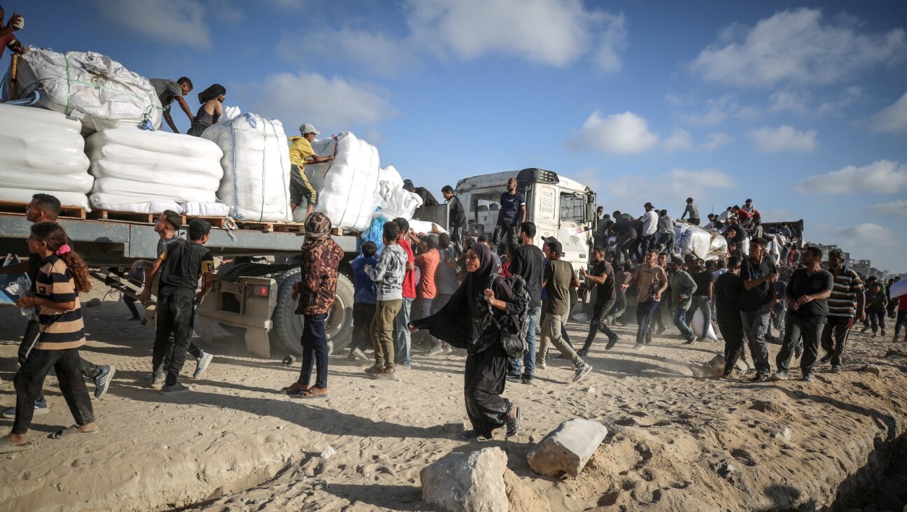 Palestinians receive aid supplies after aid trucks sent by the United Nations under Israeli attacks enter the Zakim border crossing under the protection of Palestinians and reached the warehouses in the north of in Gaza City, Gaza, on June 25, 2025. 