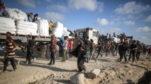 Palestinians receive aid supplies after aid trucks sent by the United Nations under Israeli attacks enter the Zakim border crossing under the protection of Palestinians and reached the warehouses in the north of in Gaza City, Gaza, on June 25, 2025. 