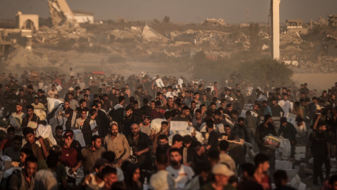 Palestinians receive aid supplies after aid trucks enter through Netzarim Corridor under Israeli attacks in Gaza Strip on June 26, 2025. 
