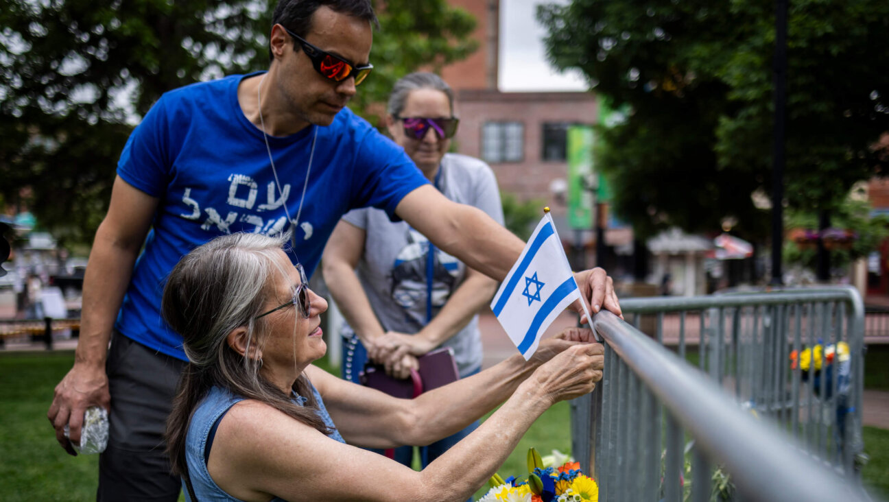 Lisa Turnquist of Louisville, Colorado, lays flowers and a flag at the site of the attack outside the Boulder County Courthouse on June 2 in Boulder, Colorado.