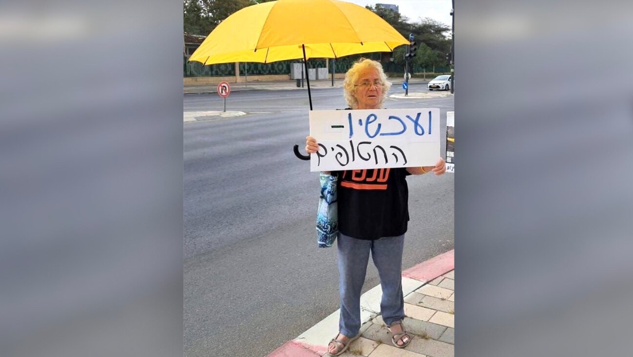 Naomi Shaanan, killed when an Iranian missile struck her apartment building in Beersheba on June 24, 2025, holds a sign in Hebrew that reads, “And now — the hostages.” 