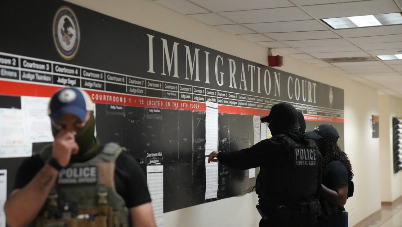 US Immigration and Customs Enforcement (ICE) agents look over lists of names and their hearing times and locations inside the Federal Plaza courthouse before making arrests on June 27, 2025 in New York.