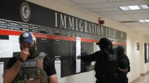US Immigration and Customs Enforcement (ICE) agents look over lists of names and their hearing times and locations inside the Federal Plaza courthouse before making arrests on June 27, 2025 in New York.