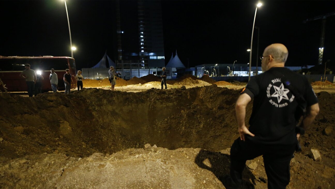A view of a giant hole as Israeli forces arrive in the area and investigate debris of missiles fired from Iran towards Israel, after they fall in Herzliya, north of Tel Aviv, Israel, Oct. 1, 2024. (Saeed Qaq/Anadolu via Getty Images)