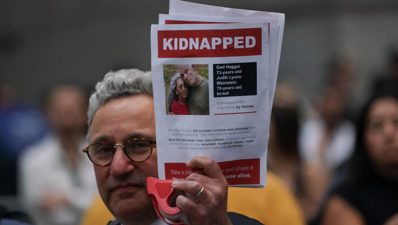 A supporter of Israel holds a picture of kidnapped Israeli hostages Gadi Haggai and Judith Weinstein Haggai during the "Flood Wall Street for Gaza" rally outside the New York Stock Exchange on Oct. 26, 2023. 