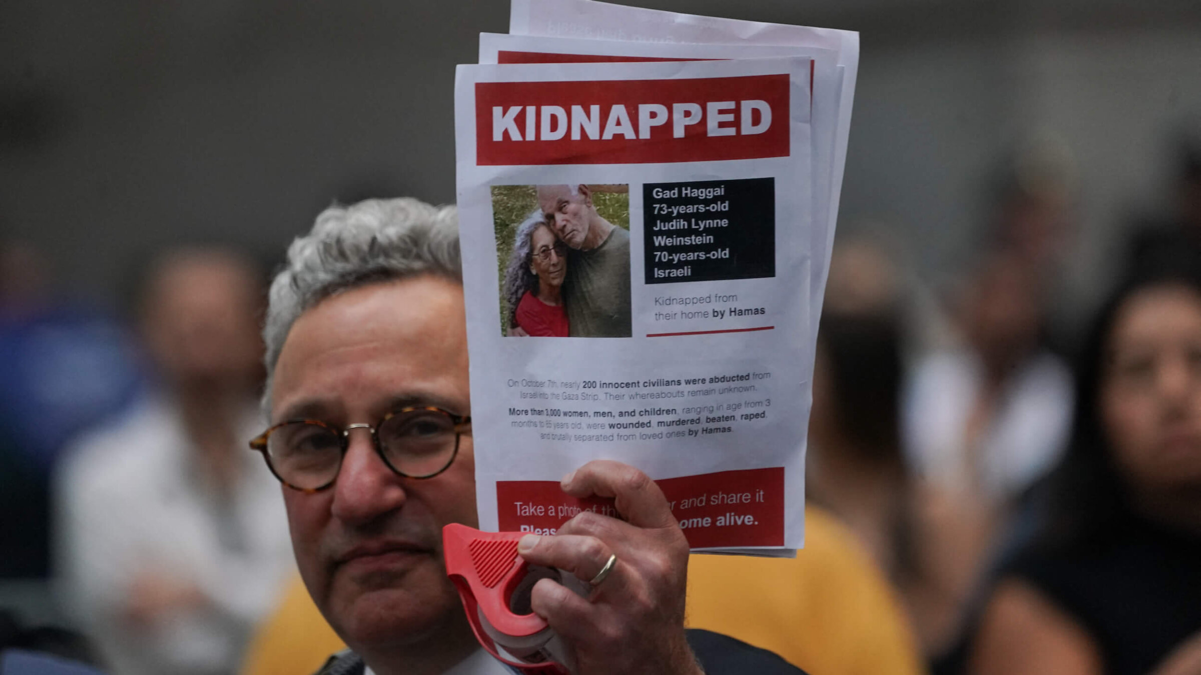 A supporter of Israel holds a picture of kidnapped Israeli hostages Gadi Haggai and Judith Weinstein Haggai during the "Flood Wall Street for Gaza" rally outside the New York Stock Exchange on Oct. 26, 2023.