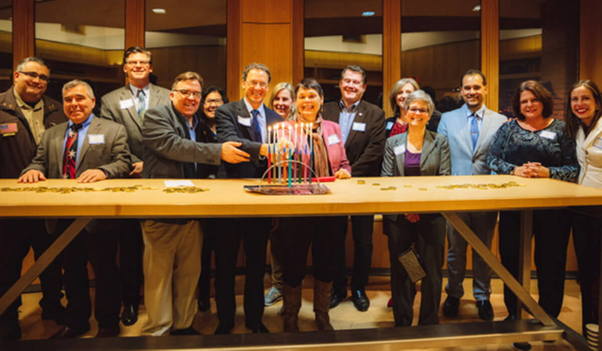 Minnesota state Sen. John Hoffman, fourth from left, and then-Speaker of the House Melissa Hortman, seventh from left, at a Jewish Community Relations Council of Minnesota and the Dakotas Hanukkah party in December 2019. The lawmakers and their spouses were both shot by a gunman posing as a police officer.