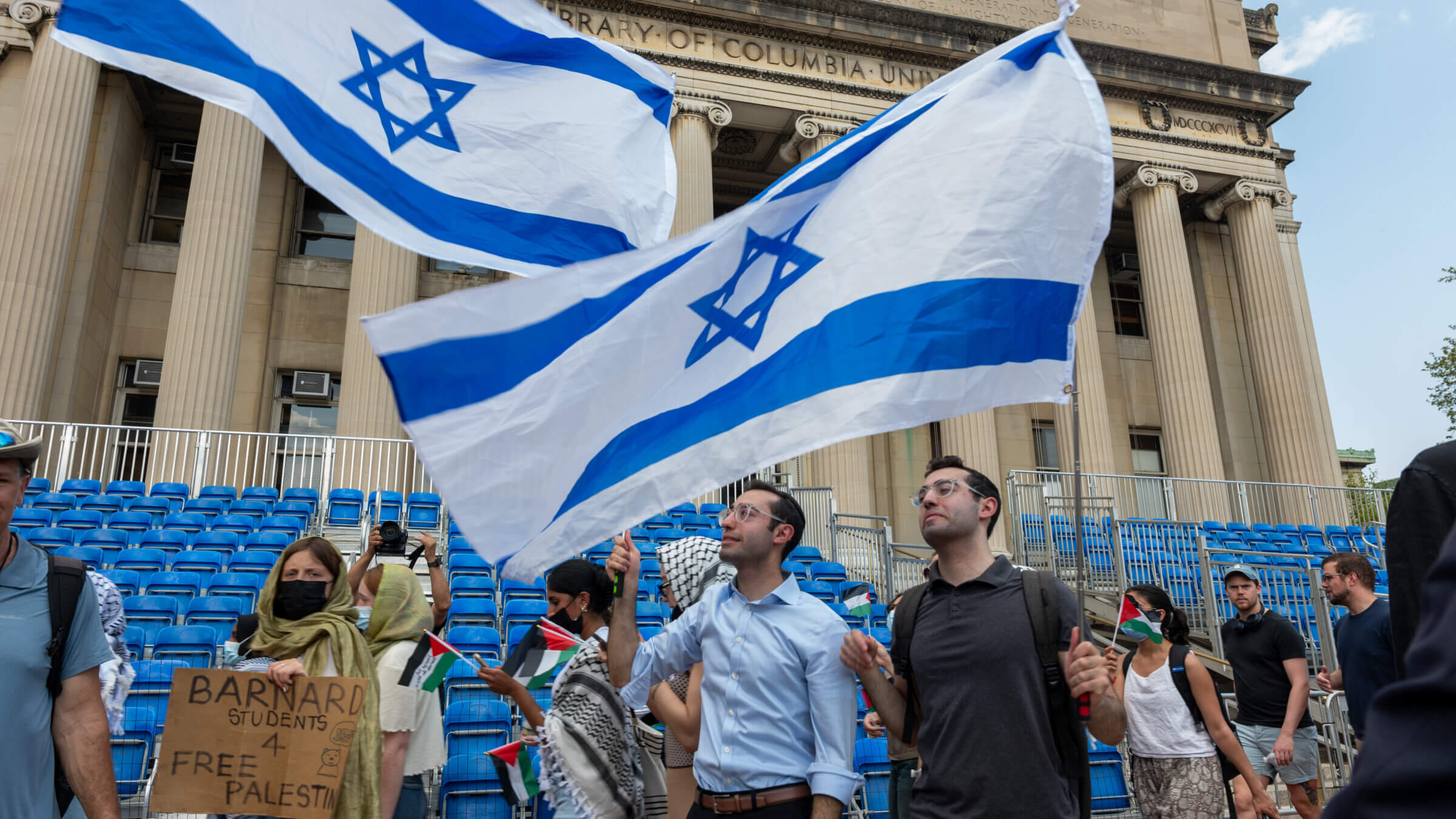 Men wave an Israeli flag as pro-Palestinian supporters continue to demonstrate from a protest encampment on the campus of Columbia University on April 29, 2024.